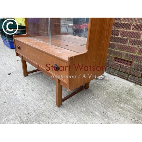 142 - A teak glazed display cabinet with a mirror glass interior over a single drawer