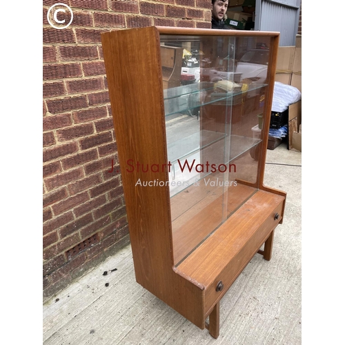 142 - A teak glazed display cabinet with a mirror glass interior over a single drawer