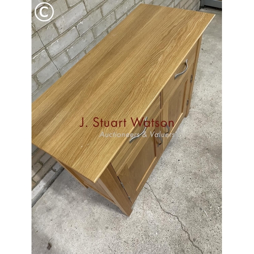 157 - A small light oak sideboard having two drawers over two cupboard doors