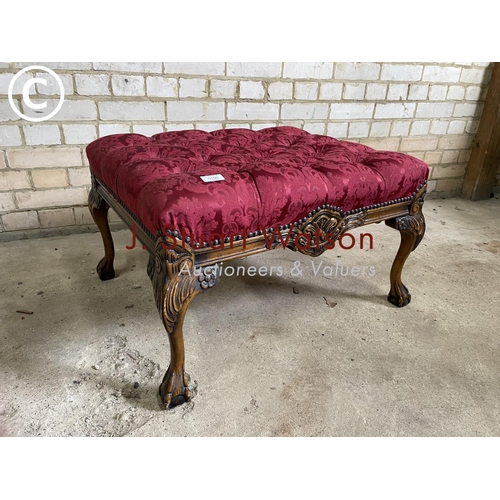 195 - A red upholstered buttoned footstool with ball and claw feet