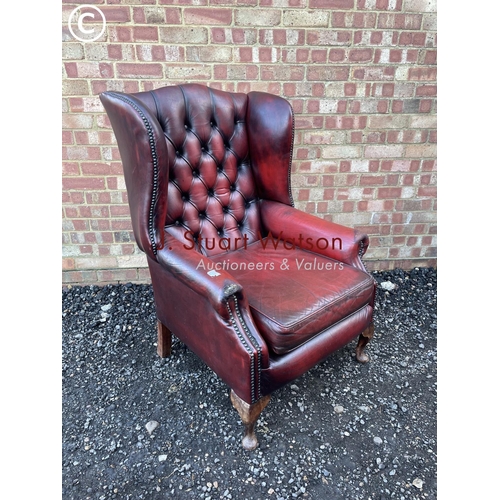 22 - A red leather chesterfield wing back chair