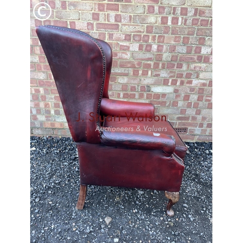 22 - A red leather chesterfield wing back chair