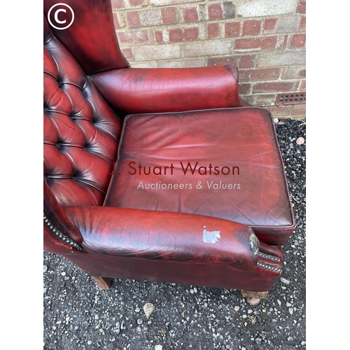 22 - A red leather chesterfield wing back chair