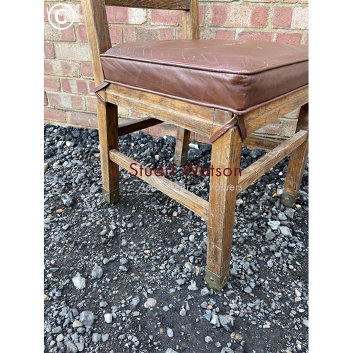 25 - An unusual oak chair with brown leather seat amd brass strapwork