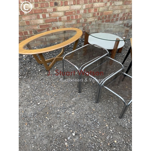 259 - A collection of retro tables including glass top nest of three, retro coffee table, circular coffee ... 