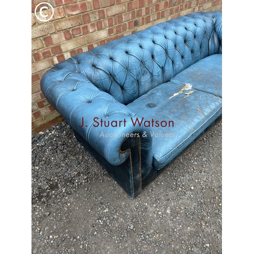 261 - A blue leather chesterfield sofa AF with castors in box