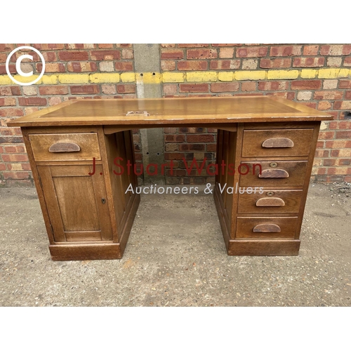 302 - An early 20th century oak pedestal desk with a brown leather top