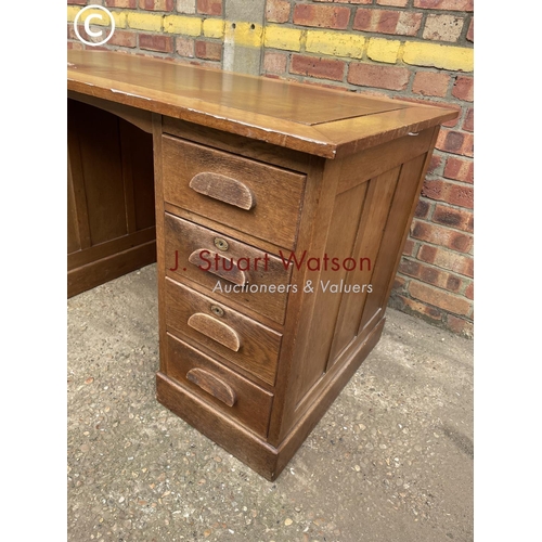 302 - An early 20th century oak pedestal desk with a brown leather top