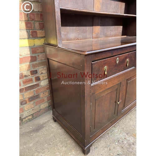 306 - An oak dresser having a plate rack top over two drawers and three cuobaord door base 145x60x195