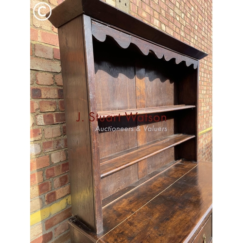 306 - An oak dresser having a plate rack top over two drawers and three cuobaord door base 145x60x195