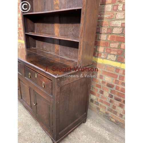 306 - An oak dresser having a plate rack top over two drawers and three cuobaord door base 145x60x195