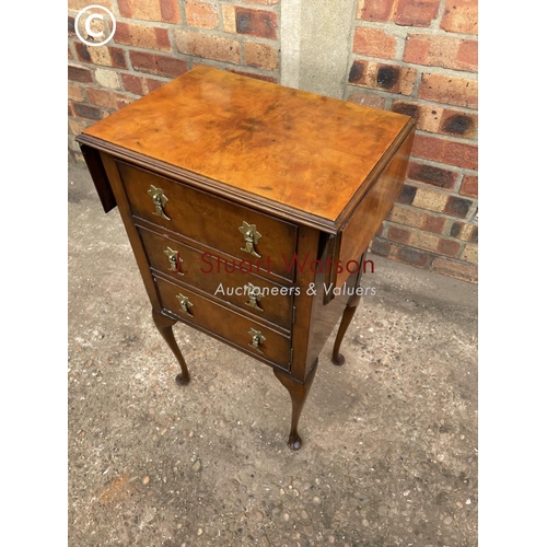 307 - A reproduction walnut side table with drawer over cupboard