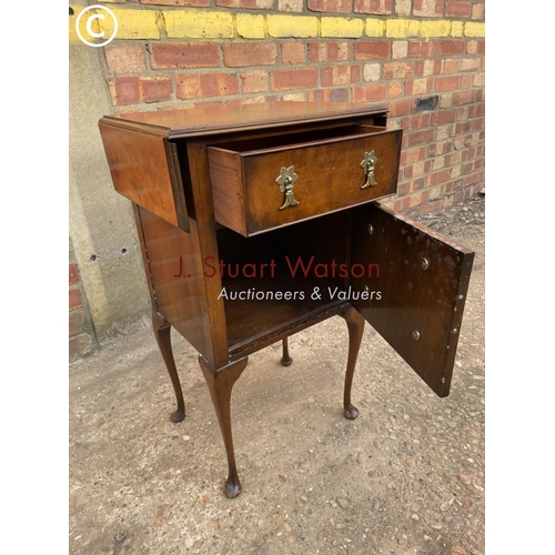 307 - A reproduction walnut side table with drawer over cupboard