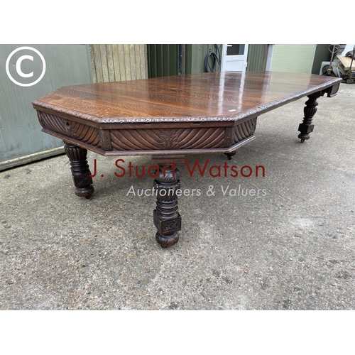 309 - A very large carved oak wind out dining table with three leaves, raised on 5 removable legs. With  H... 