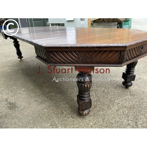 309 - A very large carved oak wind out dining table with three leaves, raised on 5 removable legs. With  H... 