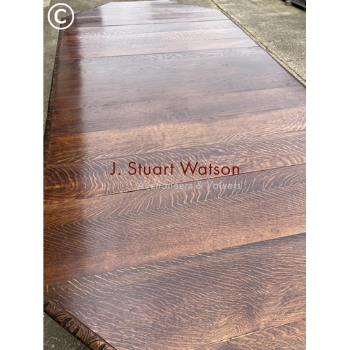 309 - A very large carved oak wind out dining table with three leaves, raised on 5 removable legs. With  H... 