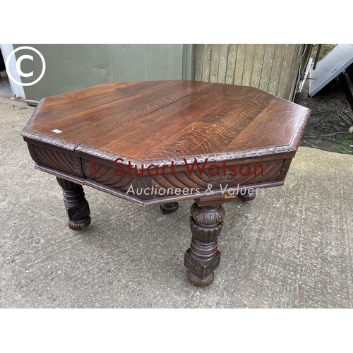 309 - A very large carved oak wind out dining table with three leaves, raised on 5 removable legs. With  H... 