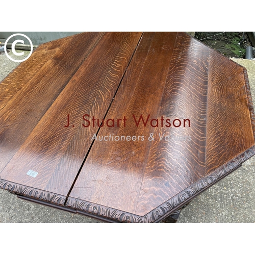 309 - A very large carved oak wind out dining table with three leaves, raised on 5 removable legs. With  H... 