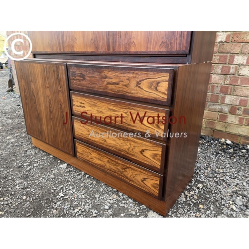 32 - A danish rosewood sideboard / bureau with a fitted interior over four drawers and a cupboard to the ... 