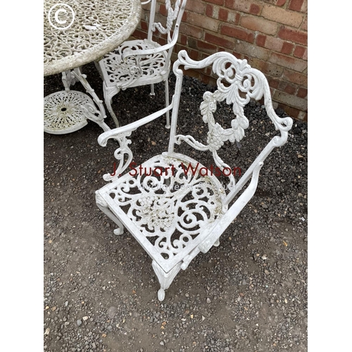 339 - An ornate circular aluminum white painted garden table together with four carver chairs 110 cm diame... 