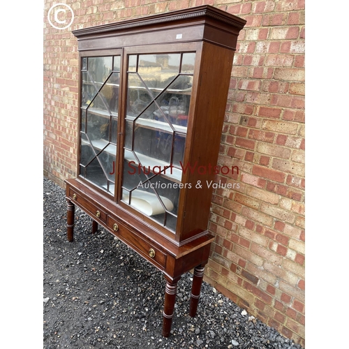 353 - A glazed mahogany cabinet on two drawer stand 145x38x190