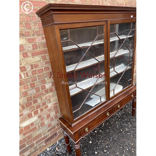 353 - A glazed mahogany cabinet on two drawer stand 145x38x190