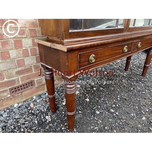 353 - A glazed mahogany cabinet on two drawer stand 145x38x190