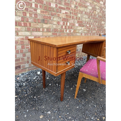 358 - A mid cemtury teak four drawer desk of curved form together with matching carver chair