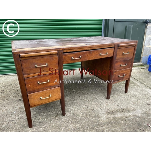 402 - An oak kneehole desk with seven drawers