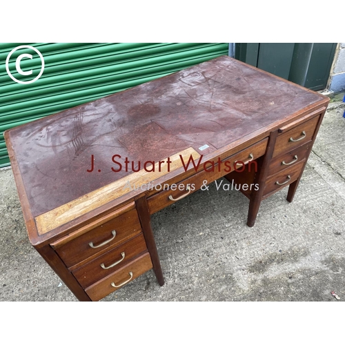 402 - An oak kneehole desk with seven drawers