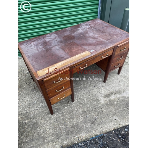 402 - An oak kneehole desk with seven drawers