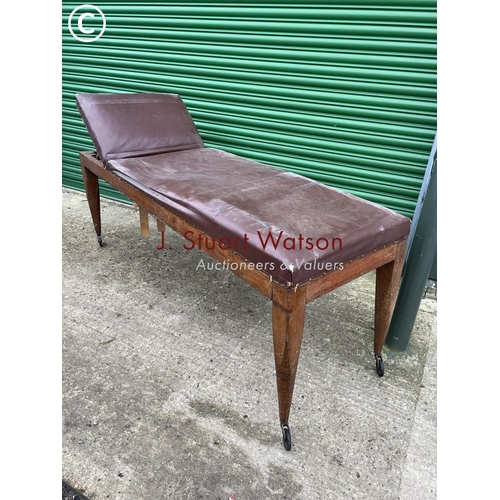 404 - An early 20th century oak framed treatment couch with horsehair upholstery top and raised in castors