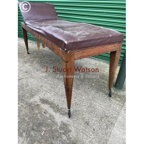 404 - An early 20th century oak framed treatment couch with horsehair upholstery top and raised in castors