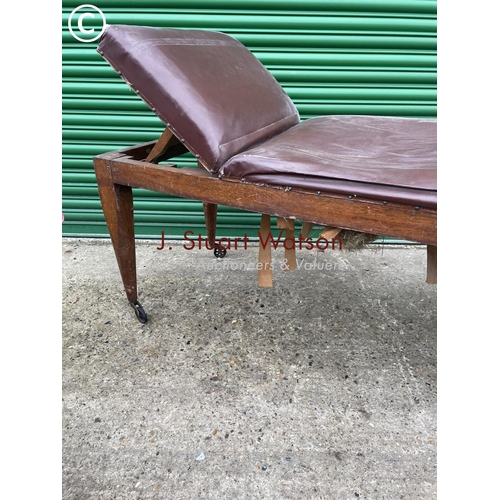 404 - An early 20th century oak framed treatment couch with horsehair upholstery top and raised in castors