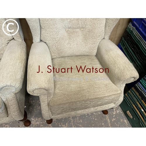 411 - A pair of modern oatmeal upholstered wing back armchairs