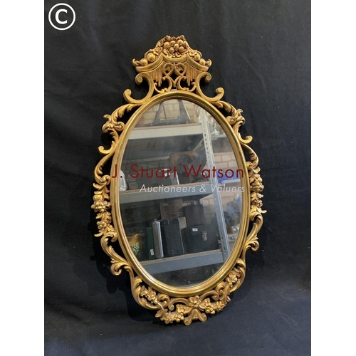 648 - Modern ornate gilt mirror height 76 cms width 48 cms