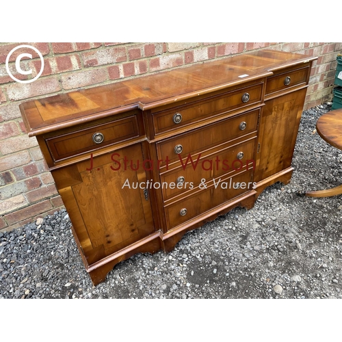 78 - A small yew wood break front sideboard together with matching occasional table