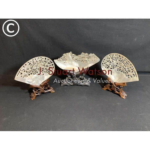 820 - Three carved fretwork Mother of Pearl shells on carved wooden stands.