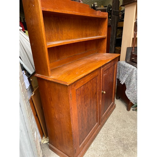 380 - An oak school room two door cupboard with bookrack top