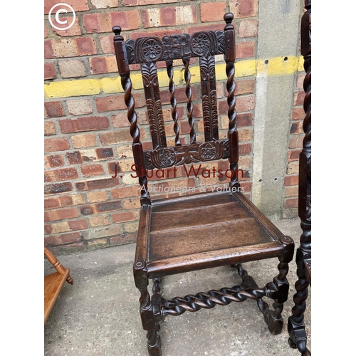 210 - A carved oak carver chair with bergere seat together with a pair of barley twist oak dining chairs