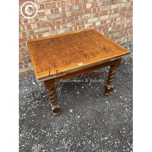 124 - An oak drawer leaf table with barley twist legs