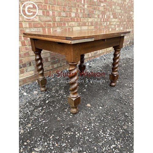 124 - An oak drawer leaf table with barley twist legs