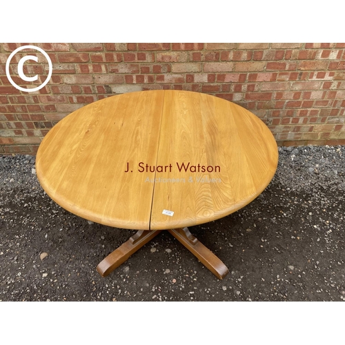 126 - An ercol elm circular dining table 115cm round