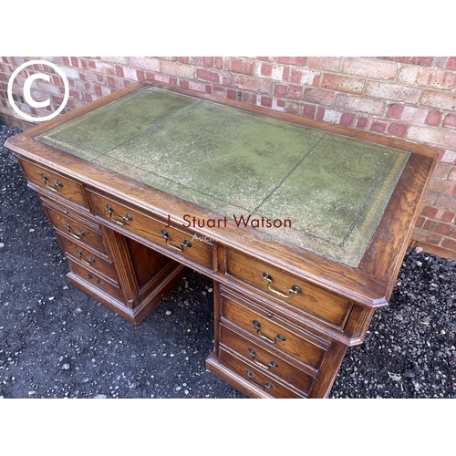 160 - An american style modern oak twin pedestal desk with green leather top