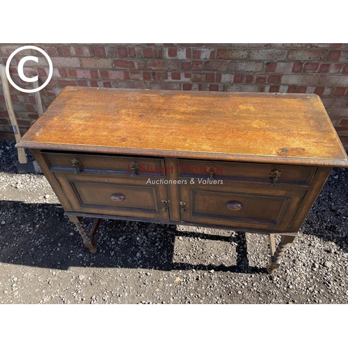 194 - An oak two drawer barley twist sideboard