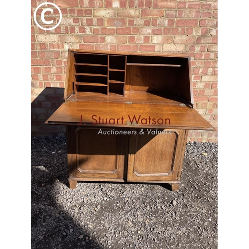 249 - A solid oak bureau with a stationery rack interior and brass handles