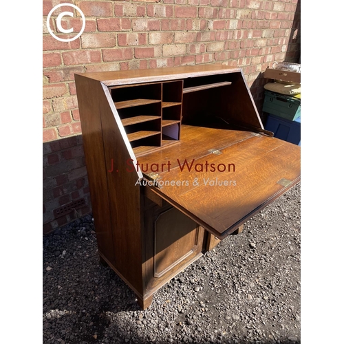 249 - A solid oak bureau with a stationery rack interior and brass handles