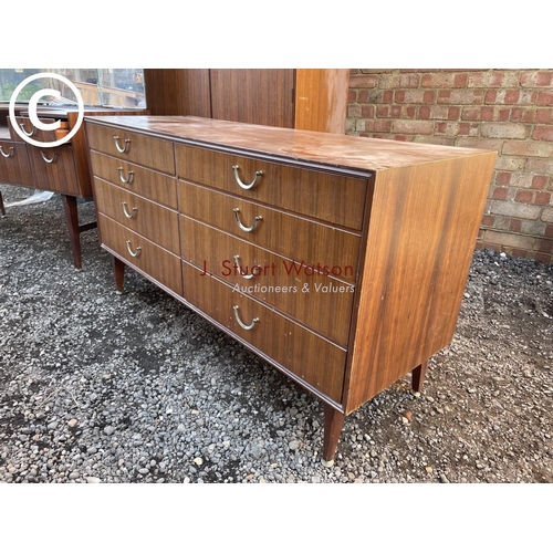 264 - A mid century teak three piece bedroom suite by meredew consisitng of a wardrobe, dressing table and... 