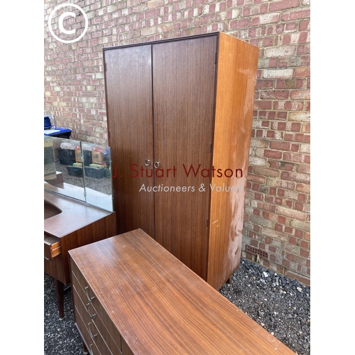 264 - A mid century teak three piece bedroom suite by meredew consisitng of a wardrobe, dressing table and... 