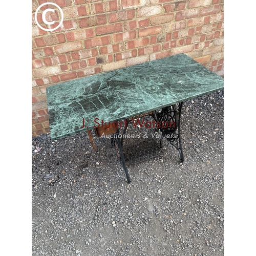 287 - An iron singer sewing machine base with later green marble loose top